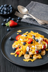 fresh berries, banana with corn flakes and yogurt