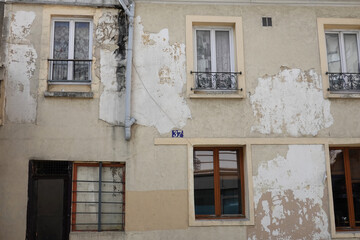 Pathologie d'une façade extérieure qui se détériore avec un décollement d'enduit