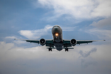 A big beautiful plane lands. Blue sky. Clouds in the sky.