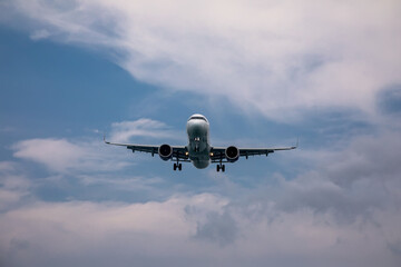 A big beautiful plane lands. Blue sky. Clouds in the sky.