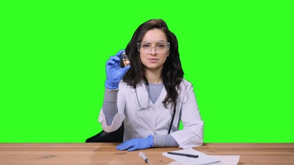 Female doctor in protective glasses holding vaccine bottle on the chroma key