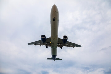 A big beautiful plane lands. Blue sky. Clouds in the sky.