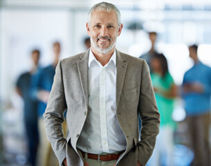 Happy, portrait and mature businessman in office with team for leadership, confident and positive...