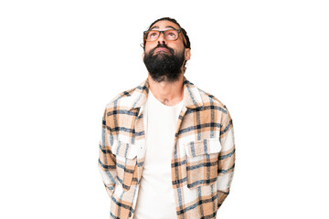 Young man with beard over isolated chroma key background and looking up