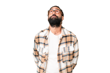 Young man with beard over isolated chroma key background and looking up