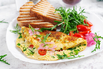 Healthy breakfast. Omelette with cheese, tomatoes   and green herbs. Omelette, salad and toast. Keto, ketogenic lunch.