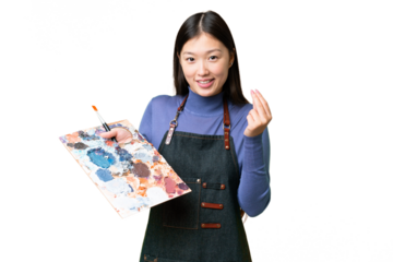 Young artist woman holding a palette over isolated chroma key background making money gesture