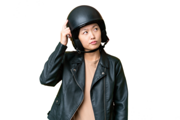 Young Asian woman with a motorcycle helmet over isolated chroma key background having doubts and with confuse face expression