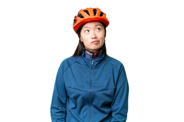 Young cyclist woman over isolated chroma key background and looking up