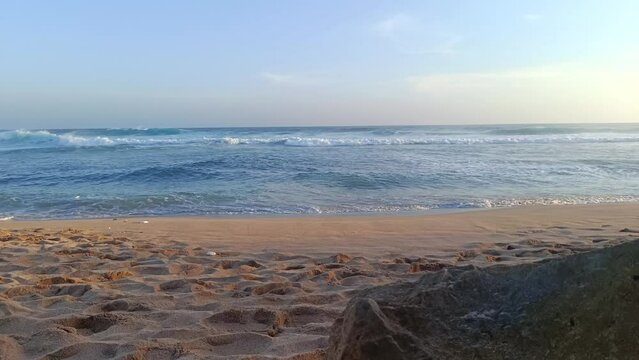 Landscape view of sea sand and coral rocks on a sunny summer day in the afternoon. Molang Beach, Tulungagung, Indonesia