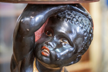 Statua, scultura puttino nero e dorato  in restauro. Artigianato restauro antiquariato.