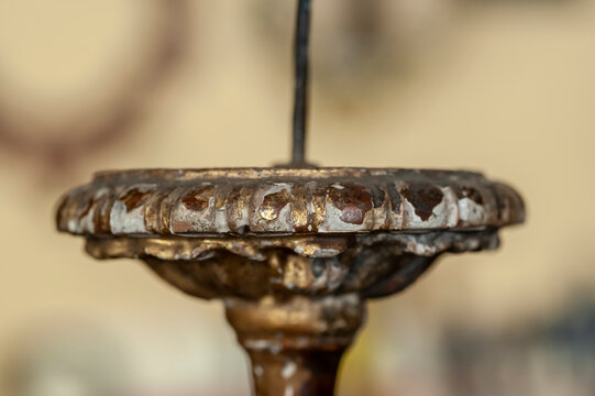 Artigiano restauro, mostra in primo piano candelabro da restaurare. Dorato, doratura, d'antiquariato.