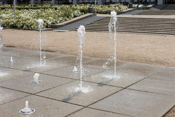Water droplets spread from the fountain in the air. Splashing water from a fountain in the park....