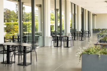 Modern outdoor terrace with seating arrangement. Fashionable outdoor cafe or restaurant tables, summer time
