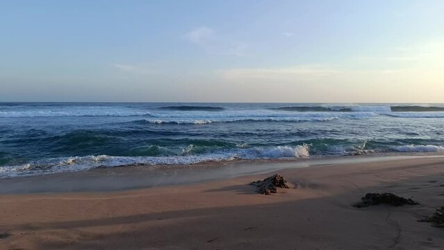 Landscape view of sea sand and coral rocks on a sunny summer day in the afternoon. Molang Beach, Tulungagung, Indonesia
