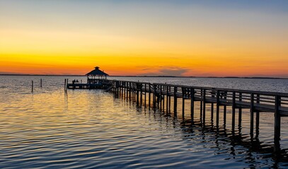 Dock leading out to a bay at sunset in the Outer Banks of North Carolina