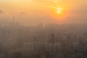 Fototapeta premium Towering urban metropolis lining the coast, backed by scenic hills in Hong Kong during the sunset