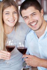Happy couple, portrait and wine with glass for date, love or romance in kitchen at home. Man and woman with smile enjoying alcohol, drink or beverage together on romantic dinner or meal at house