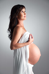 Studio, pregnant and woman with hope for stomach, growth and health of baby, body and glow with...