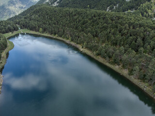 Aerial view of the mirror lake in the forest. Engolasters Lake, Canillo, Andorra.