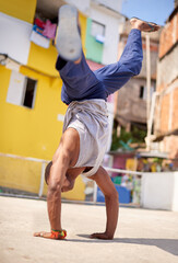Capoeira, dance and man on street in Brazil for exercise, skill and entertainment in city. Martial arts, breakdancing and male performer in Rio de Janeiro for acrobatics, spirituality or self defense