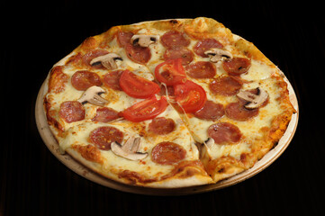 Pizza with mozzarella cheese, ham and mushrooms on wooden table