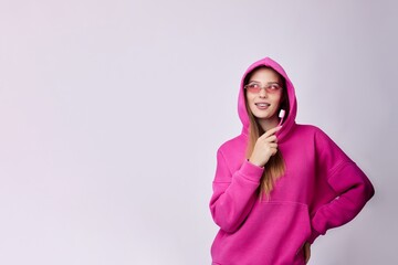 This image showcases a stylish woman in a pink hoodie and trendy sunglasses, exuding confidence and...