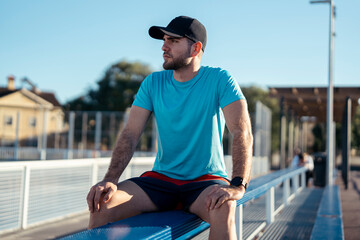 Caucasian man with a hat sitting on a bench