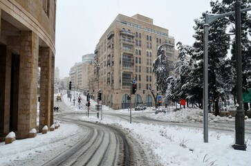 Roads covered in snow and ice as people walk down the street: Jerusalem