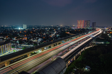 Fototapeta premium Long exposure of car light trails entering Jakarta from the Bekasi Highway Railway