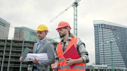 Building contractors inspecting housing complex under construction