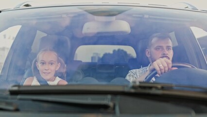 Angry father and his little daughter traveling together by car. Slow motion