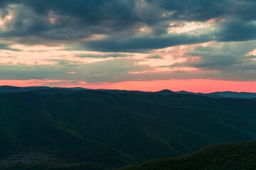 Stunning landscape of mountains in the distance, illuminated by a beautiful pink sunset