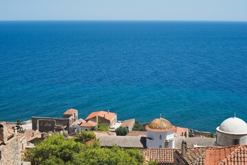 Scenic view of residential rooftops in a city near a tranquil body of water in Monemvasia, Greece