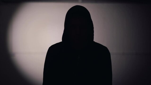 Silhouette of a person putting a gun to head