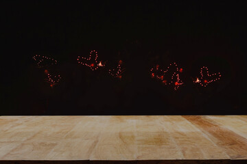 Wooden table top provides a backdrop for a spectacular heart-shaped fireworks display in the night...