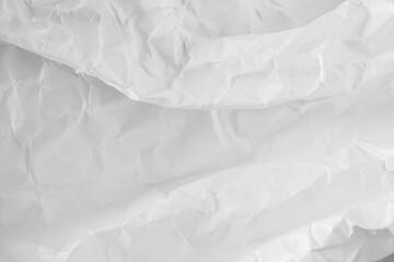 Obraz premium A heavily crumpled large sheet of paper as a background. Black and white image.