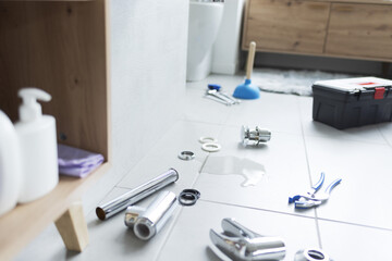 Leaking bathroom sink and plumber tools