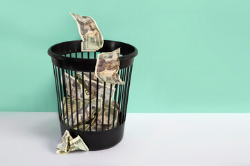 Trashcan with 20 US dollar bills. Ineffective investments concept