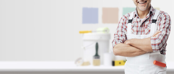 Portrait of a professional painter and painting equipment in the background © stokkete