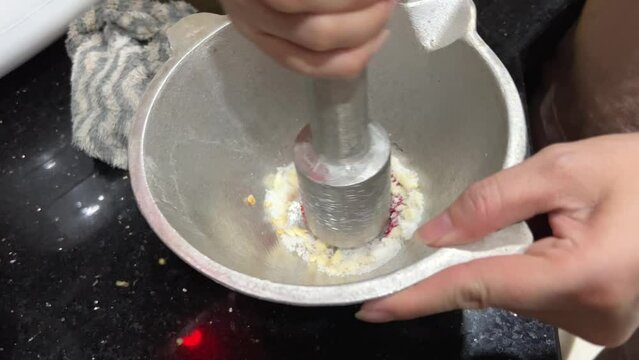 Preparing Vietnamese sauce add dry garlic, red pepper Chilli and salt stir in a mortar break into small pieces grind. Spicy sauce. Marinade