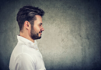 Side profile portrait of a cheerful young smiling unshaved handsome man 