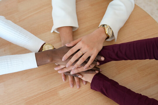 Diverse team of women demonstrating unity with a hand stack