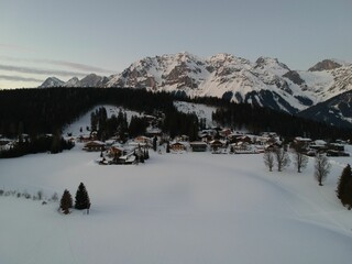 a ski slope that has many small buildings in the snow