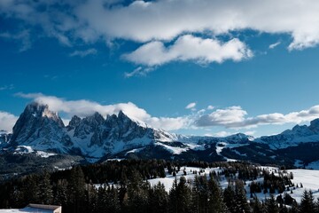 Stunning view of Seceda mountain, framed by a beautiful blue sky and fluffy white clouds