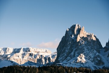 Stunning view of Seceda mountain, framed by a beautiful blue sky and fluffy white clouds