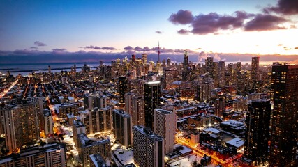 Aerial view of a vibrant cityscape of Toronto including CN Tower, with tall buildings and lights