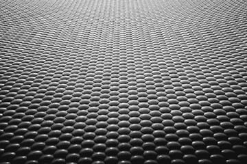 Monochrome pattern of black and white spheres arranged on a uniform surface.