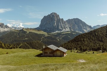Rustic log cabin nestled in the foothills on the background of the Seceda mountain
