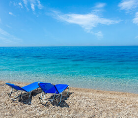 Summer morning beach with sunbeds, white sand and pebble (Albania).